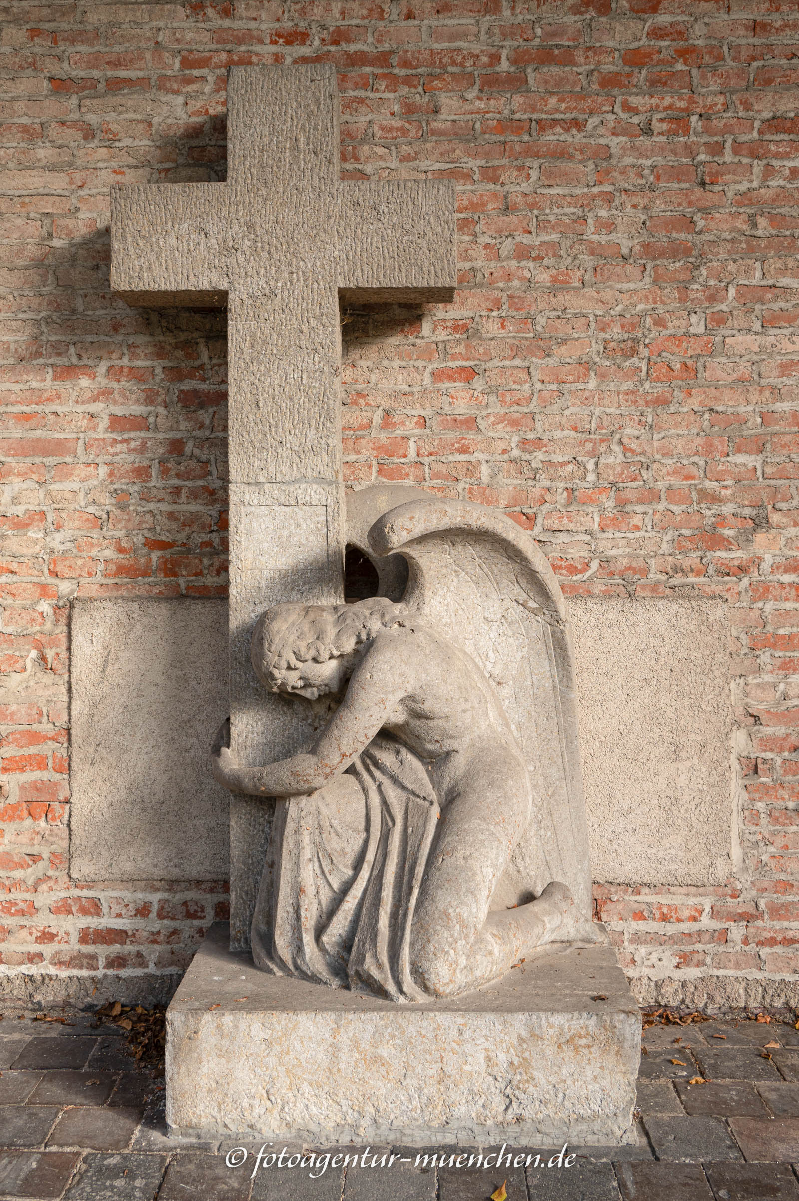 Kniender Engel vor dem Kreuz